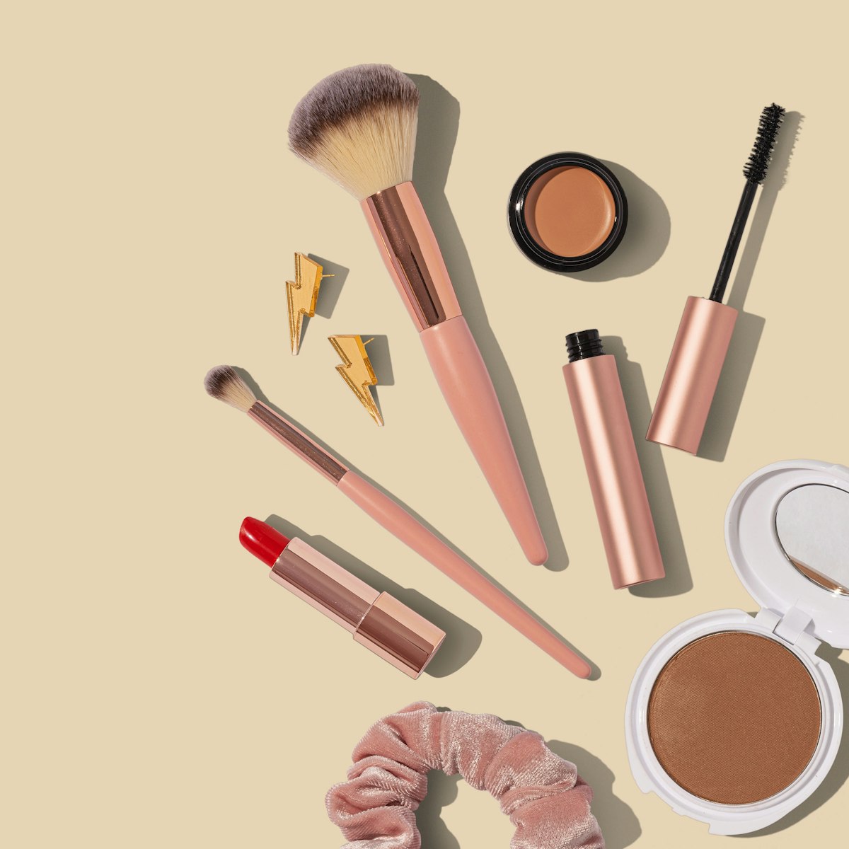 Beautyproducten en kwasten in warme roze tinten